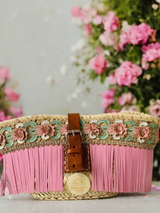 Capazo bandolera de palma flecos rosa.